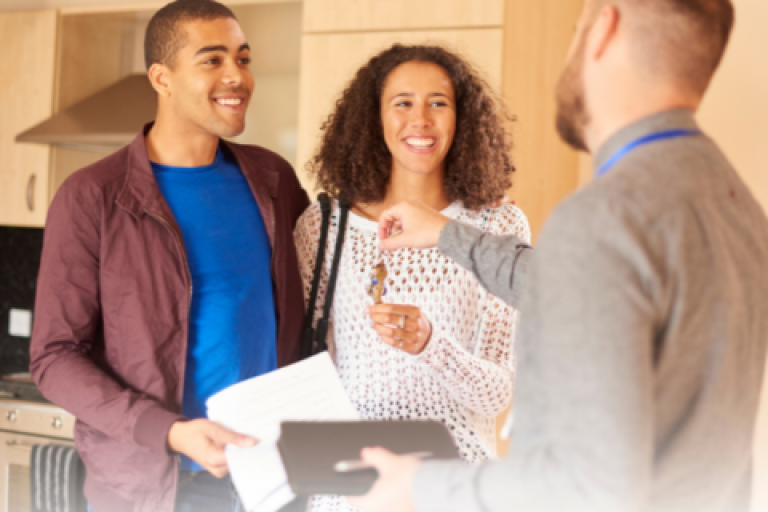 Estate agent handing keys to buyers