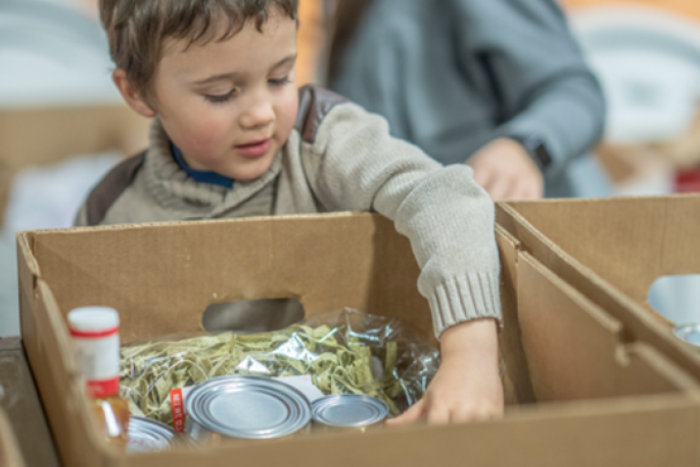 Child looking at a box of donated items