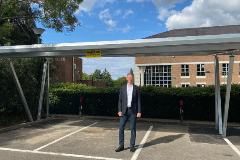 Cllr Young in front of the solar car port