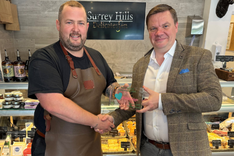 Cllr Robin Stephens presenting Surrey Hills Delicatessen with their award.