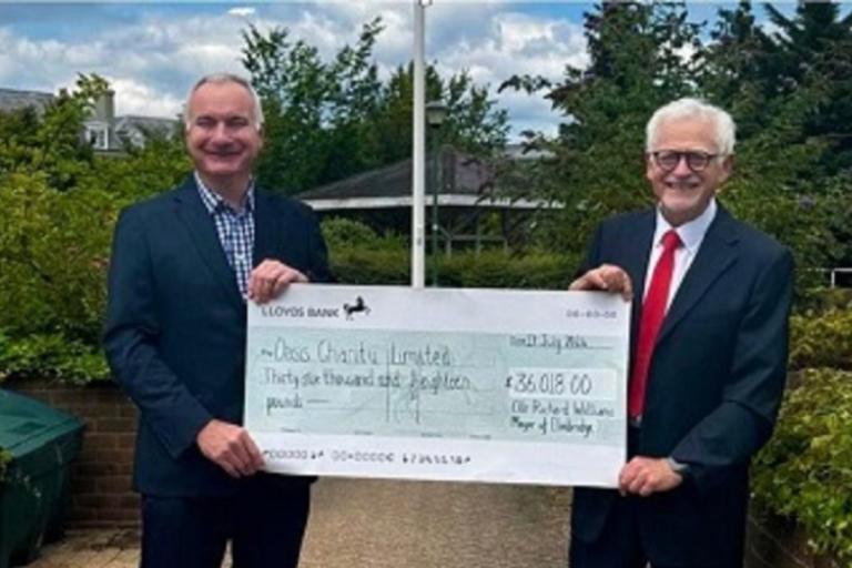 Richard Williams and Graham Farmer- Chairman of the Board of Trustees from Oasis holding a large cheque