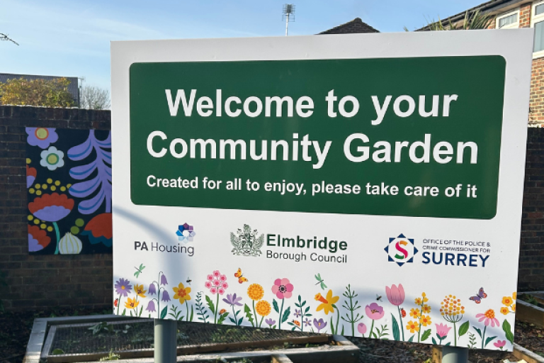 Sign stating 'Welcome to your Community Garden' with flowers across the bottom.