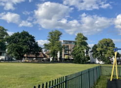 A green space in Hersham surrounded by a playground and residential buildings.
