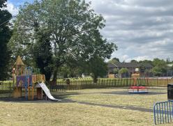 play are with slide and roundabout and large tree