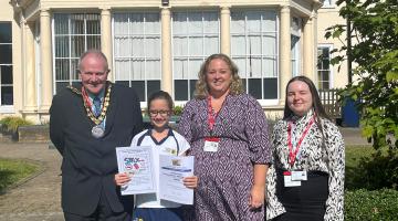 Cllr Neil Houston Mayor of Elmbridge, prize winner Belle, Kim Tagliarini Strategic Director Elmbridge Borough Council, Tamsin Vigar, Community Safety Officer Elmbridge Borough Council standing on grass in front of building