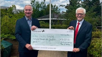 Richard Williams and Graham Farmer- Chairman of the Board of Trustees from Oasis holding a large cheque