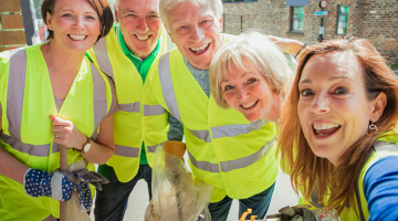 Five people in high visibility jackets litter picking