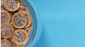 A dish of pound coins against a light blue background