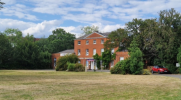 red brick building surrounded by green space and trees